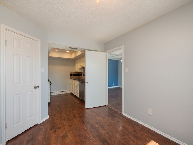 kitchen with a textured ceiling, visible vents, dishwasher, baseboards, and dark wood-type flooring