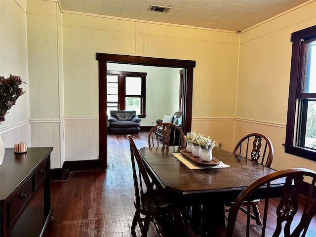 1106 Lexington St, Taylor, TX 76574 - dining area featuring dark wood-type flooring, a decorative wall, visible vents, and ornamental molding