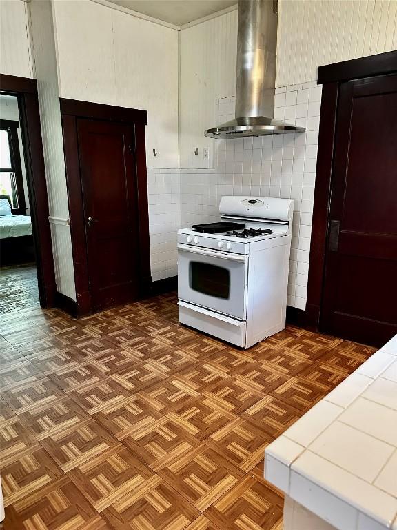1106 Lexington St, Taylor, TX 76574 - kitchen with ventilation hood, tile walls, tile countertops, and gas range gas stove
