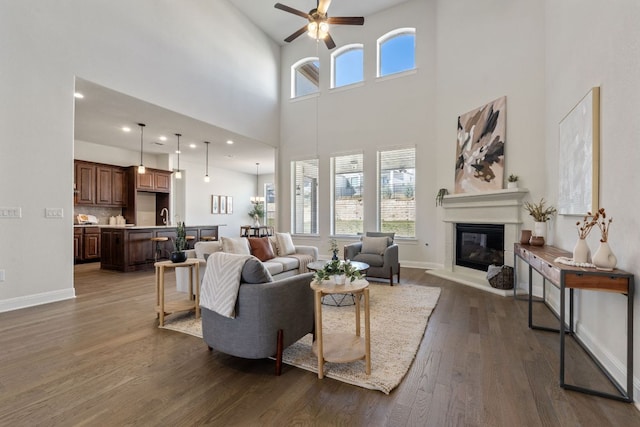 4709 Napoli Shore Dr, Leander, TX 78641 - living area with a glass covered fireplace, ceiling fan, dark wood-type flooring, and a high ceiling