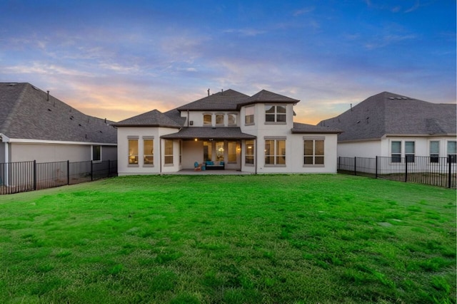 4709 Napoli Shore Dr, Leander, TX 78641 - back of property at dusk featuring a fenced backyard, a patio area, and stucco siding