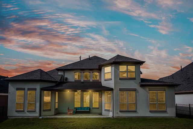 4709 Napoli Shore Dr, Leander, TX 78641 - back of property at dusk with stucco siding, a patio area, and roof with shingles