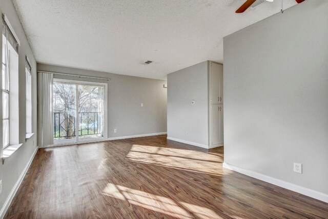 2712 Windswept Cv, Austin, TX 78745 - unfurnished room with a ceiling fan, wood finished floors, and a textured ceiling