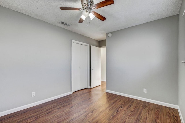 2712 Windswept Cv, Austin, TX 78745 - unfurnished bedroom with wood finished floors, a textured ceiling, a closet, and a ceiling fan
