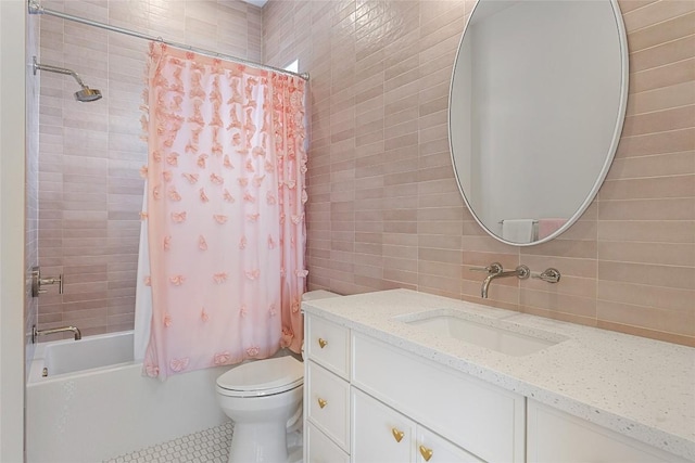 bathroom with tile patterned flooring, toilet, vanity, tile walls, and shower / bath combo
