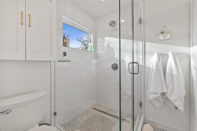 bathroom with toilet and a stall shower