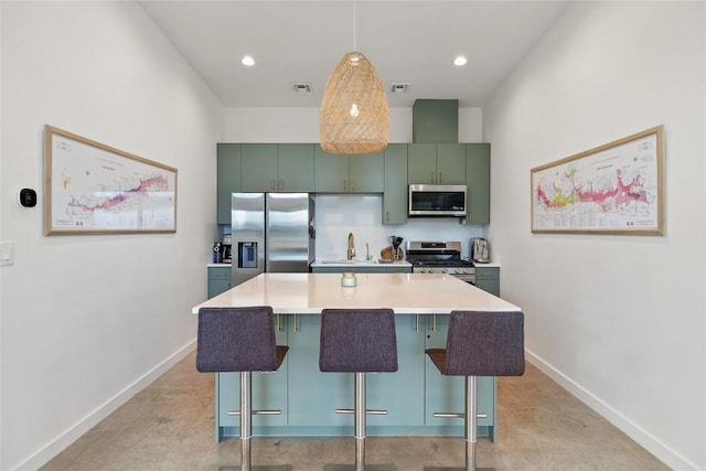 kitchen featuring baseboards, a kitchen bar, and appliances with stainless steel finishes