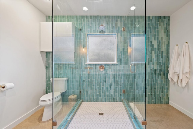 bathroom with baseboards, toilet, and a stall shower