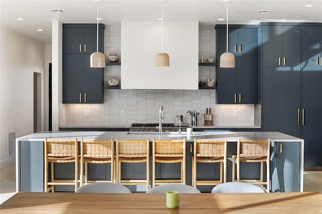 kitchen featuring modern cabinets, a breakfast bar, visible vents, and tasteful backsplash