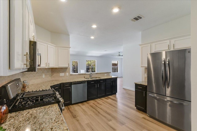 3905 Stonehenge Path, Round Rock, TX 78681 - kitchen with appliances with stainless steel finishes, a sink, decorative backsplash, white cabinetry, and light stone counters
