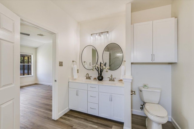 3905 Stonehenge Path, Round Rock, TX 78681 - bathroom featuring double vanity, wood finished floors, baseboards, and toilet