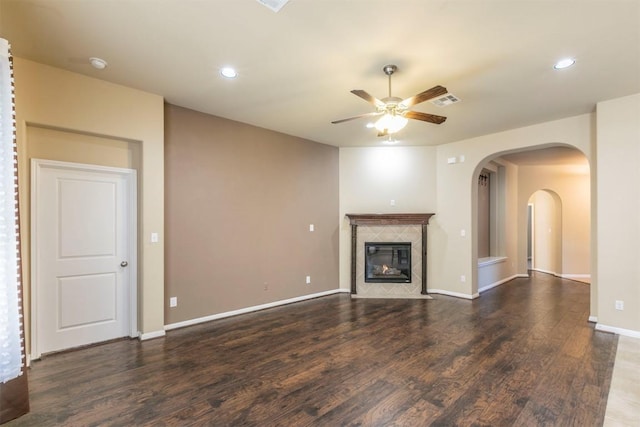 254 Chisholm Trl, Bastrop, TX 78602 - unfurnished living room with ceiling fan, wood finished floors, recessed lighting, a premium fireplace, and arched walkways