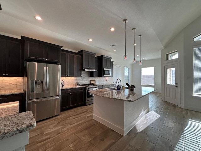 2905 Lago Costa Dr, La Marque, TX 77568 - kitchen with light stone counters, wood finished floors, appliances with stainless steel finishes, and a sink