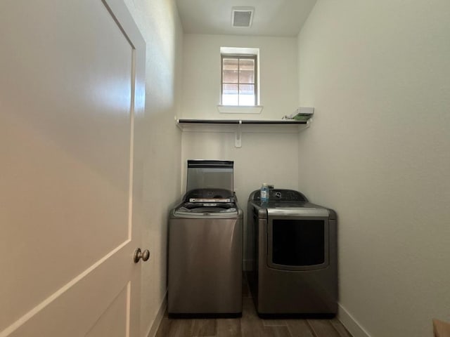 2905 Lago Costa Dr, La Marque, TX 77568 - clothes washing area with visible vents, baseboards, laundry area, wood finished floors, and washer and dryer