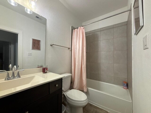 2905 Lago Costa Dr, La Marque, TX 77568 - bathroom with visible vents, toilet, shower / tub combo, a textured wall, and vanity