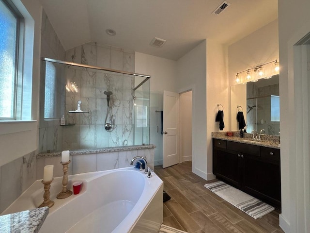 2905 Lago Costa Dr, La Marque, TX 77568 - full bath featuring wood finish floors, visible vents, a garden tub, and a stall shower