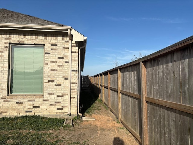 2905 Lago Costa Dr, La Marque, TX 77568 - view of home's exterior featuring brick siding, a fenced backyard, and roof with shingles
