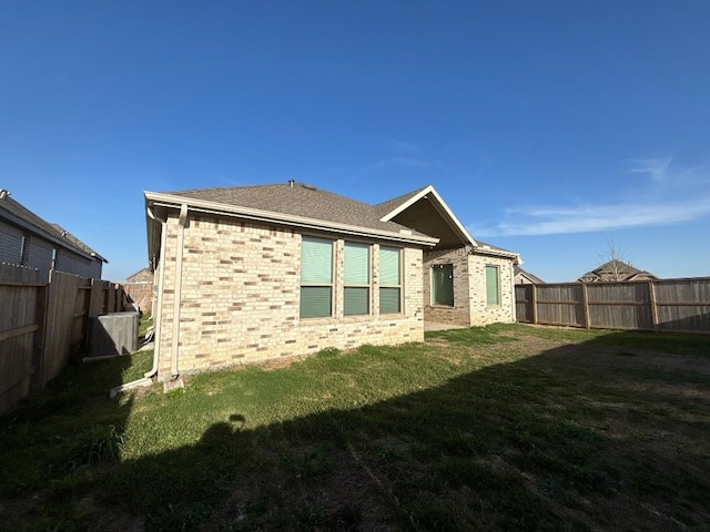 2905 Lago Costa Dr, La Marque, TX 77568 - rear view of house featuring a yard, a fenced backyard, and brick siding
