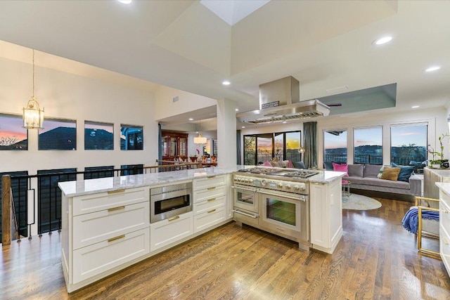 4732 Twin Valley Dr, Austin, TX 78731 - kitchen with stainless steel appliances, open floor plan, wood finished floors, white cabinetry, and recessed lighting