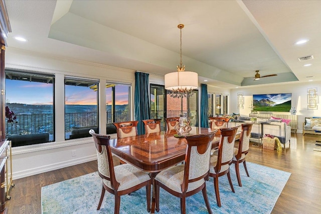 4732 Twin Valley Dr, Austin, TX 78731 - dining room featuring a tray ceiling, wood finished floors, recessed lighting, baseboards, and a chandelier