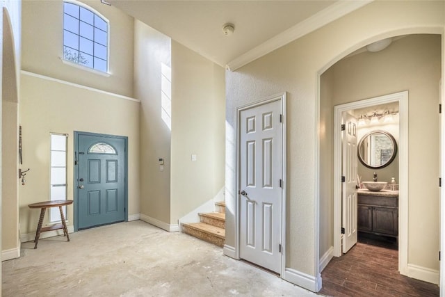 106 Remington Run, Bastrop, TX 78602 - entryway featuring ornamental molding, stairway, a towering ceiling, arched walkways, and wood finished floors
