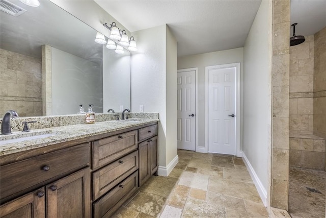 106 Remington Run, Bastrop, TX 78602 - full bath featuring stone tile flooring, double vanity, and a walk in shower