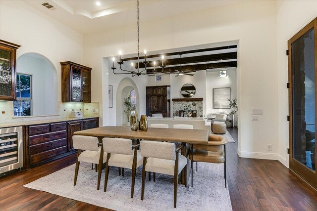 3312 Pearce Rd, Austin, TX 78730 - dining area with wine cooler, dark wood finished floors, arched walkways, a ceiling fan, and beamed ceiling