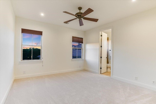 empty room featuring light carpet, recessed lighting, baseboards, and ceiling fan