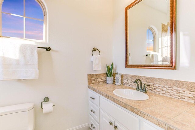 3312 Pearce Rd, Austin, TX 78730 - half bath featuring vanity, toilet, and decorative backsplash