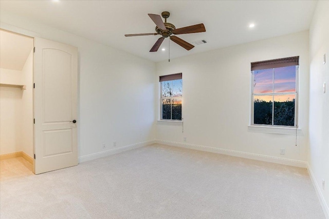 unfurnished bedroom featuring recessed lighting, light colored carpet, visible vents, and baseboards