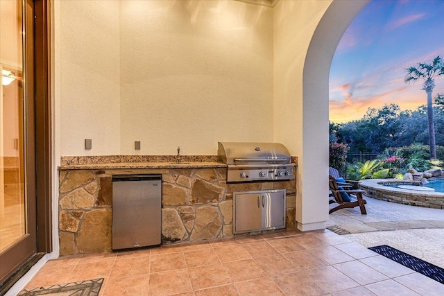 patio terrace at dusk featuring area for grilling and grilling area