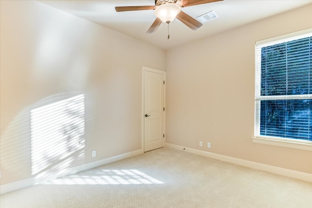 carpeted empty room featuring visible vents, baseboards, and ceiling fan