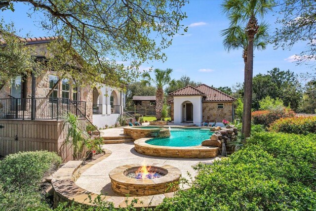 3312 Pearce Rd, Austin, TX 78730 - view of swimming pool featuring an outdoor structure, a patio area, an outdoor fire pit, and a pool with connected hot tub