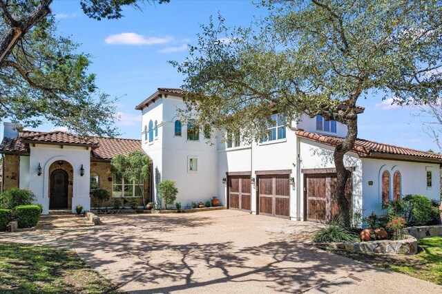 3312 Pearce Rd, Austin, TX 78730 - mediterranean / spanish-style home featuring a tile roof, an attached garage, concrete driveway, and stucco siding