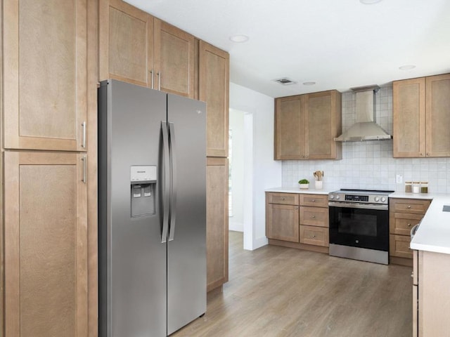 1403 E Applegate Dr, Austin, TX 78753 - kitchen featuring appliances with stainless steel finishes, wall chimney exhaust hood, light wood-style flooring, light countertops, and backsplash