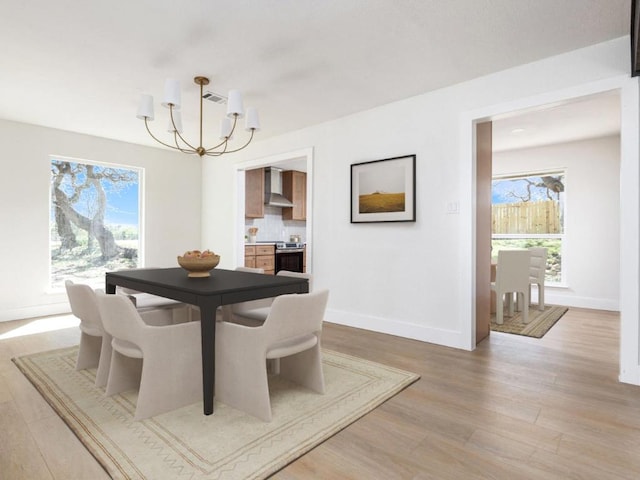 1403 E Applegate Dr, Austin, TX 78753 - dining space featuring a chandelier, light wood finished floors, healthy amount of natural light, and baseboards