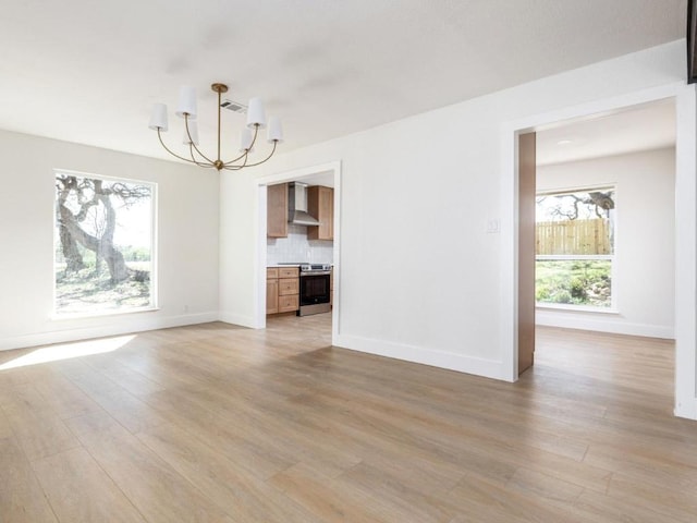1403 E Applegate Dr, Austin, TX 78753 - unfurnished living room featuring a chandelier, light wood-type flooring, and baseboards