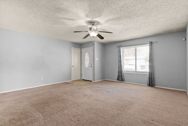 unfurnished room featuring a textured ceiling, light carpet, baseboards, and ceiling fan