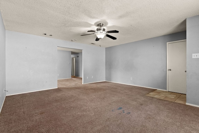 unfurnished room featuring a textured ceiling, carpet flooring, visible vents, and ceiling fan