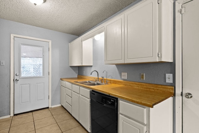 kitchen with light tile patterned floors, white cabinets, black dishwasher, and a sink