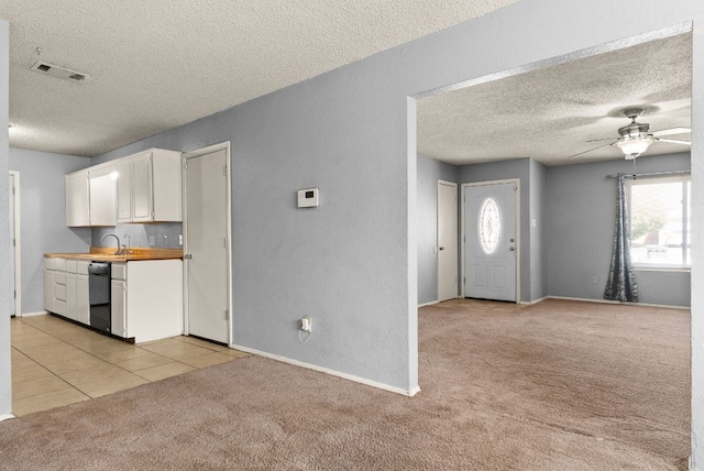 kitchen featuring visible vents, light carpet, plenty of natural light, and white cabinetry