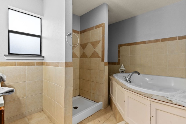 full bath with tile patterned flooring, a stall shower, a jetted tub, and tile walls