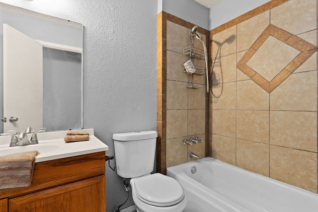 bathroom with vanity, toilet, a textured wall, and shower / bathtub combination