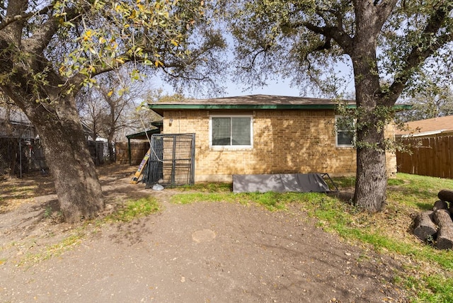 exterior space featuring brick siding and fence