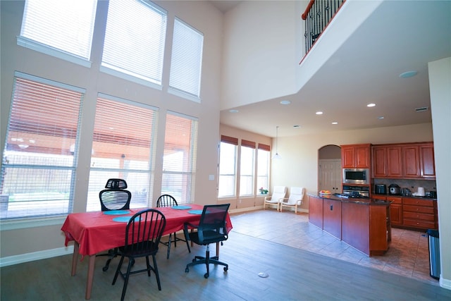 11608 Spicewood Pkwy Unit 38, Austin, TX 78750 - dining room with arched walkways, light wood-type flooring, a high ceiling, and recessed lighting