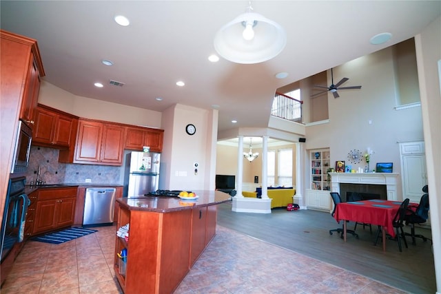 11608 Spicewood Pkwy Unit 38, Austin, TX 78750 - kitchen featuring stainless steel appliances, a tiled fireplace, open floor plan, a kitchen island, and recessed lighting