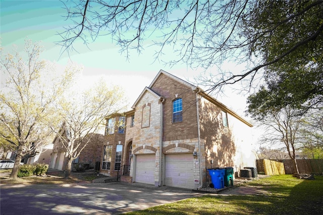 11608 Spicewood Pkwy Unit 38, Austin, TX 78750 - view of side of home featuring an attached garage, concrete driveway, and stone siding