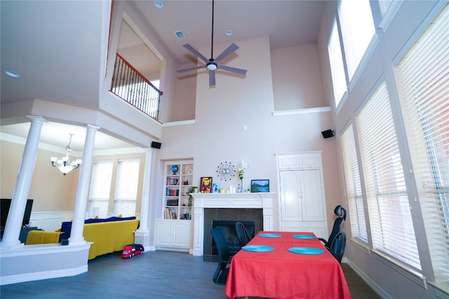 11608 Spicewood Pkwy Unit 38, Austin, TX 78750 - dining space featuring a ceiling fan, a tiled fireplace, ornate columns, a high ceiling, and wood finished floors