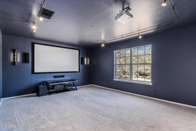 cinema with track lighting, a textured ceiling, carpet, and baseboards
