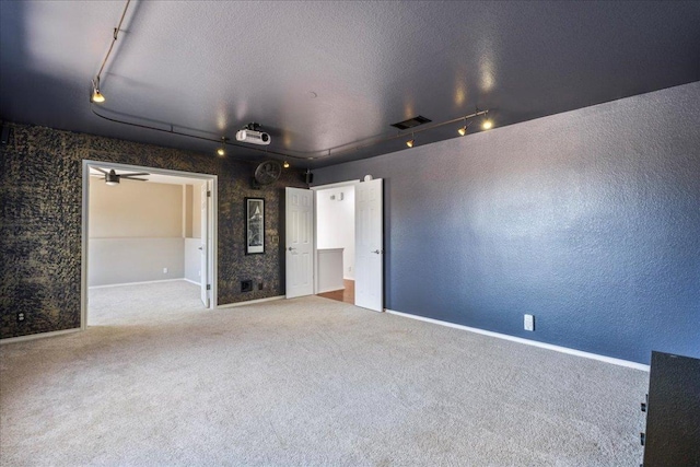 12413 Fairfax Ridge Pl, Austin, TX 78738 - carpeted spare room featuring track lighting, baseboards, a textured wall, and a textured ceiling